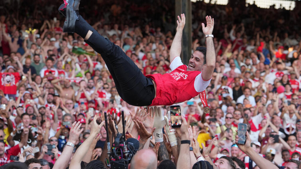 Mikel Arteta, entraîneur d'Arsenal, célébré par ses joueurs après le titre de champion de Premier League, marquant le renouveau du club anglais.