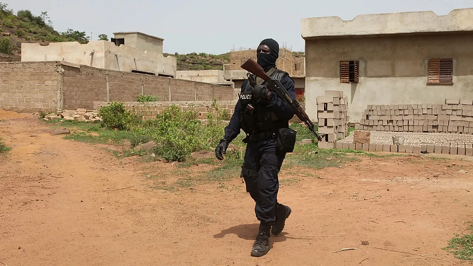 Policier malien en patrouille devant un complexe touristique près de Bamako