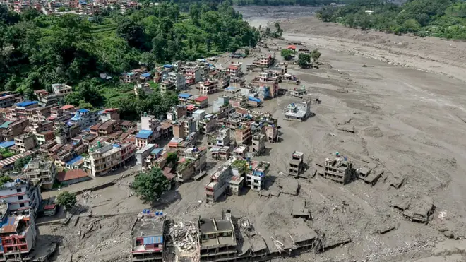 Vue aérienne des berges inondées, avec des maisons et des bâtiments partiellement submergés, au bazar de Trishuli, dans le district de Nuwakot au Népal.